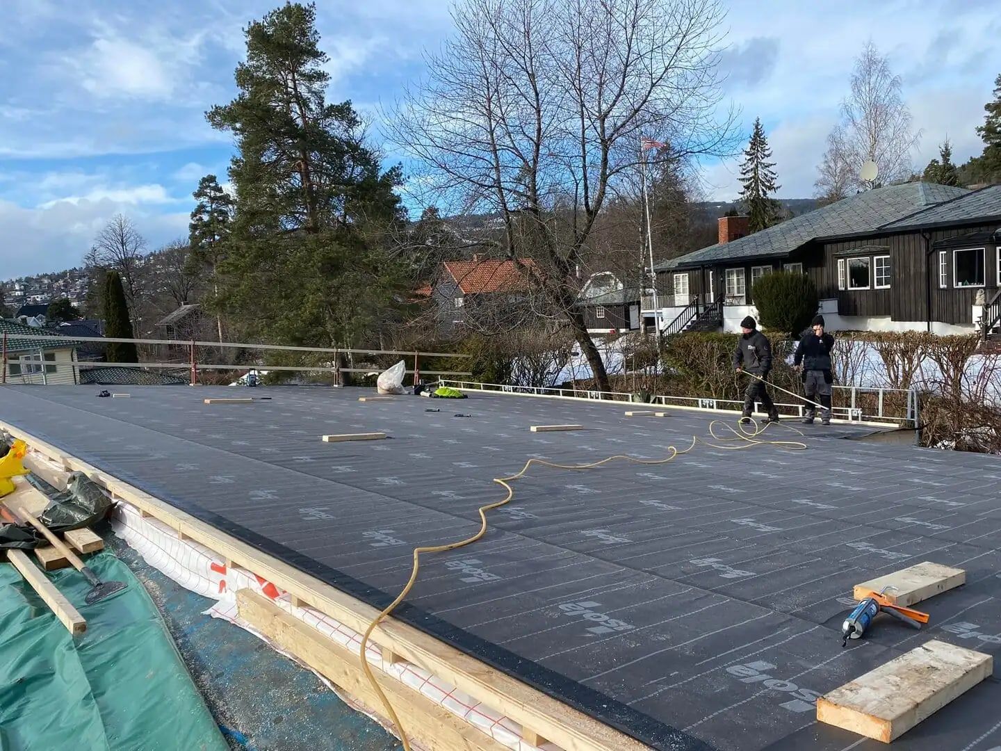 Taktekking med shingel på en bolig, to fagarbeidere i arbeid