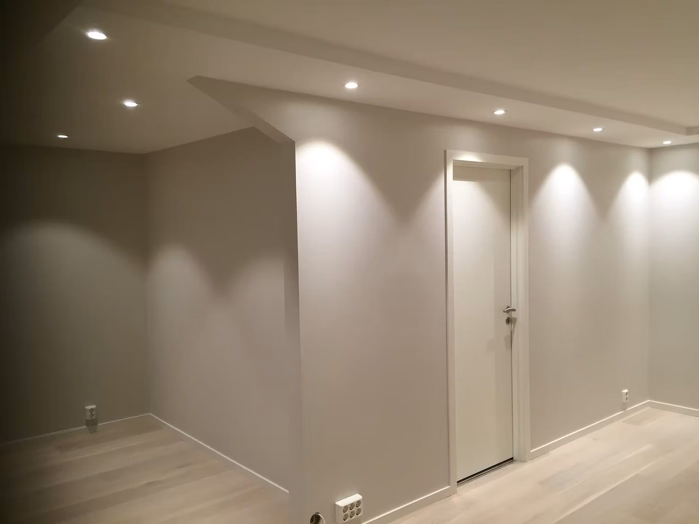 Ferdig innredet rom med nedfelt himling, downlights og lys parkett.