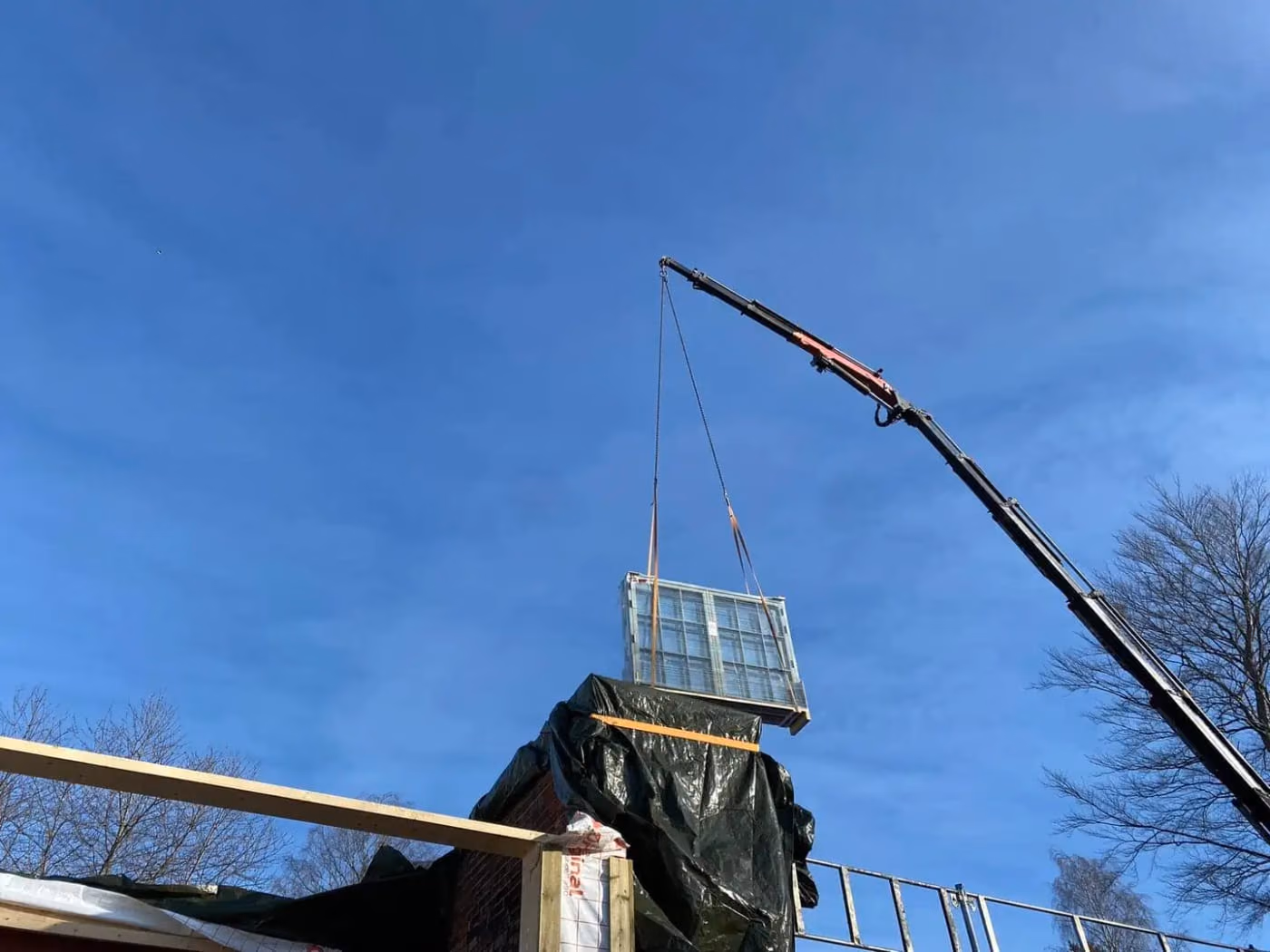 Profesjonell løft av container med kran, utført av Bærum Bygg og Graveservice, spesialisert innen bygg- og gravearbeid, med fokus på sikkerhet og effektivitet.