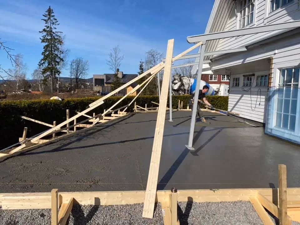 Bilde av taktekking og terrassebygging i Bærum, med treverk og byggearbeidere som jobber på taket av en bolig. Perfekt for bygg- og gravearbeid i Bærum.