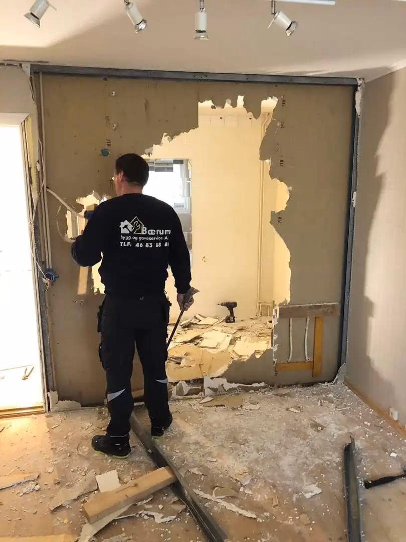 Profesjonell rivning av vegg innendørs av Bærum Bygg og Graveservice, med fokus på bygg- og gravearbeid, klar for oppussing eller ombygging.