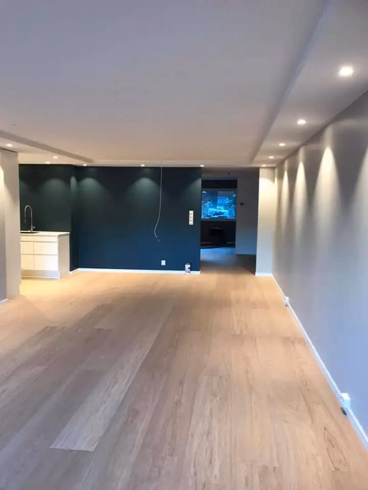 Bilde av en moderne stue med tre veggfarger, parkettgulv og innfelt belysning, perfekt for boligrenovering og interiørdesign i Bærum.