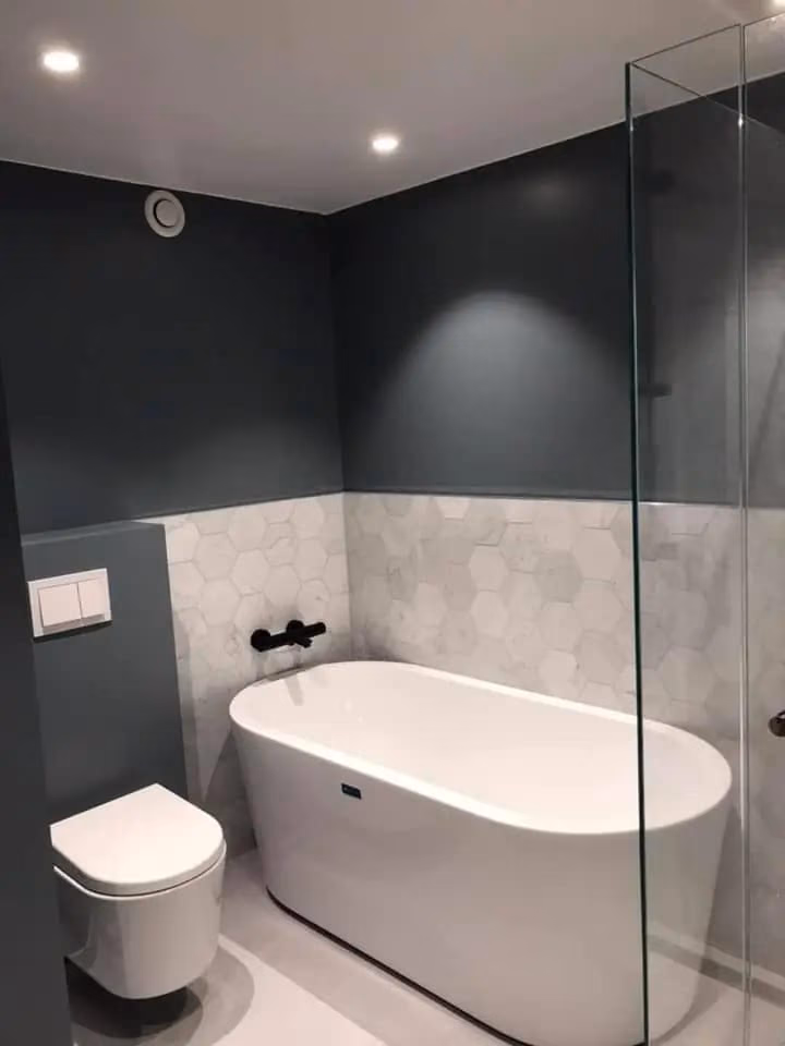 Elegant bad med badekar, dusjvegg og moderne design, perfekt for komfort og stil i hjemmet. Ideell for badrenovering og baderomsprosjekter.