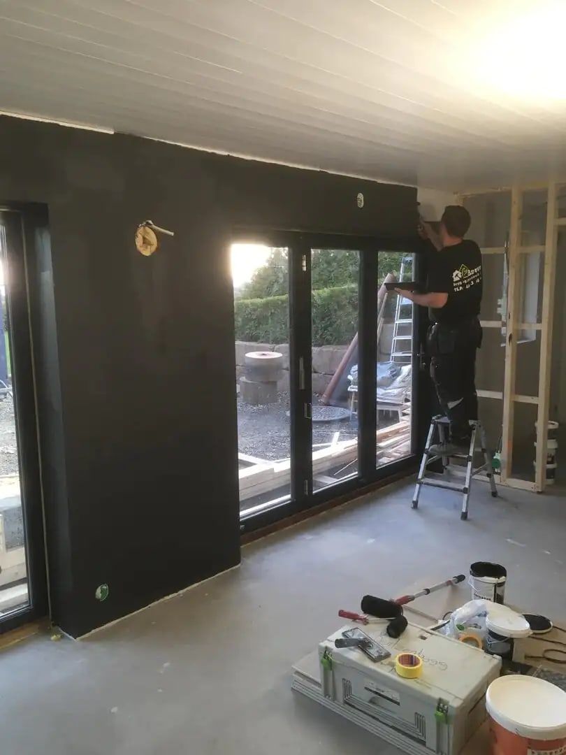 Stue under innvendig oppussing, med store vinduer
